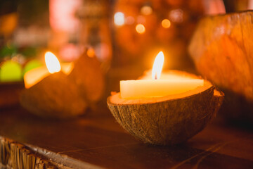 coconut with lit candle in a wooden table