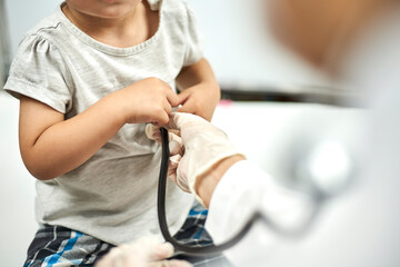 Doctor trying to listen to baby heartbeat. Physical examination of the 1-year-old baby boy....