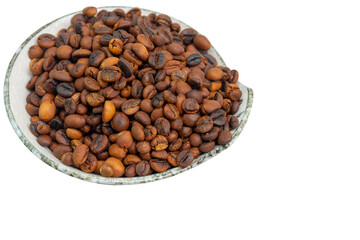 Roasted Coffee beans in a ceramic plate on a white background