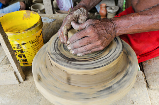 Artes&atilde;o trabalhando com argila torneando pe&ccedil;a no distrito de Icoaraci.