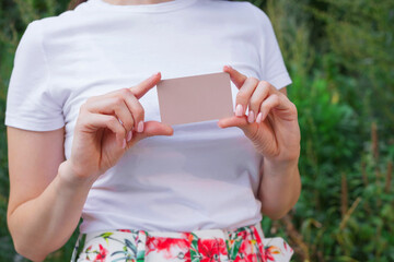 Girl holds a card for online purchases anywhere. Sale. Discounts.