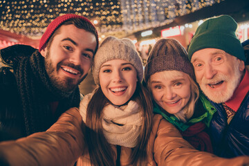 Closeup photo of full family four members x-mas gathering meeting take selfie portrait cheerful smile wear outerwear hat scarf coat two generation night street illumination outdoors outside