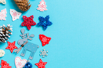 Top view of New Year toys and decorations on blue background. Christmas time concept with empty space for your design