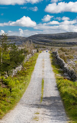 tourists walking  roadway in through the Burren national park in County Clare, Ireland