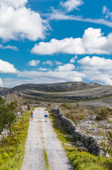 tourists walking  roadway in through the Burren national park in County Clare, Ireland