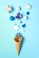 Waffle cone with christmas elements on blue background. 