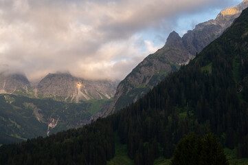 Beautiful scenic view of the Alp mountains with  green grass on a sunset.