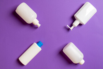 Set of White Cosmetic containers isolated on colored background, top view with copy space. Group of plastic bodycare bottle containers with empty space for you design