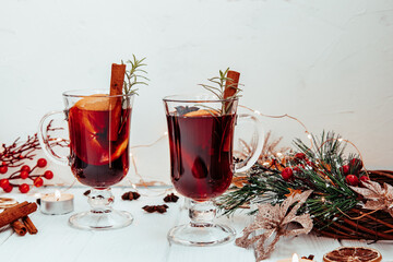  hot homemade mulled wine with rosemary on a white plate in a New Year's atmosphere. beautiful background with copy-space