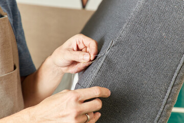Qualified workman upholstering furniture in repair furniture