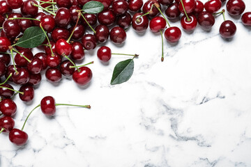 Obraz na płótnie Canvas Sweet juicy cherries on white marble table, flat lay. Space for text
