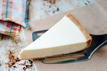 Piece of baked homemade cheesecake desert on baking sheet