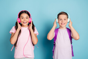 Photo excited two small kids classmates boy girl have lesson break pause listen headset modern...