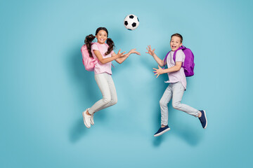Fototapeta na wymiar Full length body size view of two attractive small little cheerful cheery buddy fellow friends friendship jumping play soccer cup goal hobby leisure free time isolated blue pastel color background