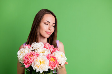 Close-up portrait of her she nice attractive pretty charming dreamy cheery girl enjoying festal mom mother day holding in hands smelling fresh flowers copy space isolated green color background
