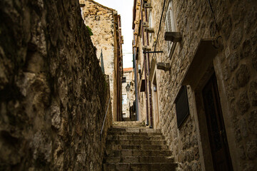 Callejón de escaleras con fachas y pared de piedra