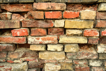 wall of red yellow and orange bricks. old crumbling wall