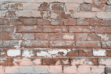 red wall with peeled pink paint. old brick wall in the city