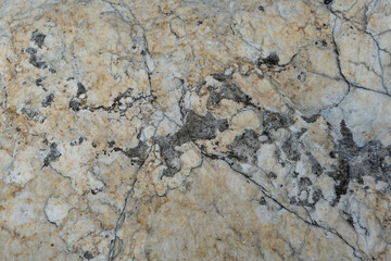 Texture of a rough natural stone of yellow and brown color.