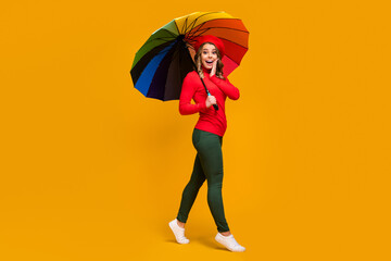 Full length body size view of nice attractive lovely amazed cheerful cheery wavy-haired girl holding in hand parasol going having fun isolated on bright vivid shine vibrant yellow color background © deagreez