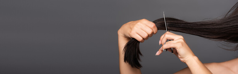 cropped view of naked brunette woman cutting hair isolated on black, panoramic shot