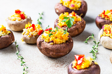 Stuffed portobello mushrooms with bulgur, vegetables and aromatic herbs on concrete background. Vegetarian food.
