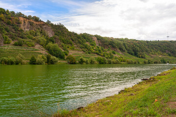 The Moselle river in western Germany near the mouth of the river in Koblenz in the background of hills and trees, the water flows calmly.