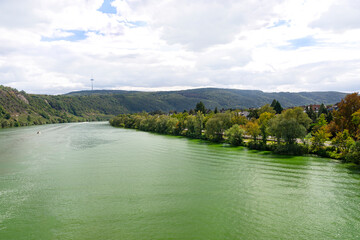 The Moselle river in western Germany near the mouth of the river in Koblenz in the background of hills and trees, the water flows calmly.