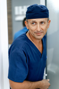 Smiling Doctor Looking At Side While Walking In The Room. Male Medic Near Entrance To The Surgery Room. Portrait. Closeup.