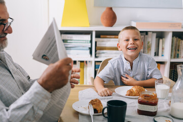grandson with his grandfather having breakfast at home