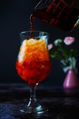 Homemade Thai iced / ice tea on dark moody background, selective focus