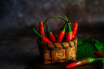 Homegrown red chillies still life on dark moody background, selective focus