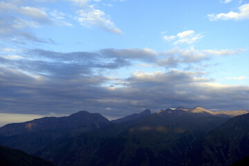Obraz premium Mountain ranges at sunset. Dusk. Silhouettes of mountains in the evening haze. Mountain ranges at sunset. Dusk.
