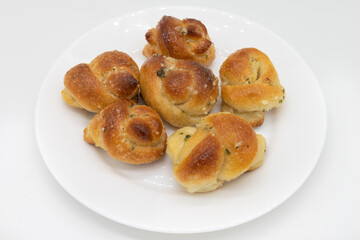 Six Garlic Knots on a White Plate with a White Background