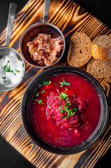 Beetroot soup Traditional Ukrainian or Russian borscht with sour cream in a bowl on wooden table