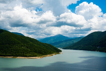 Obraz premium mountain lake with blue turquoise clear water against the backdrop of a clear sky and mountain hills
