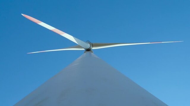 Close up wind turbines. Curvy road through Eolic park. Green ecological power energy generation. Wind farm eco field
