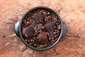 Feijoada. Traditional Brazilian food. Wood background. Top view. Copy space.
