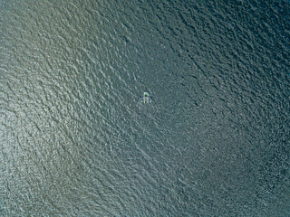 Aerial drone view. Fishing boat on the waves of the river.