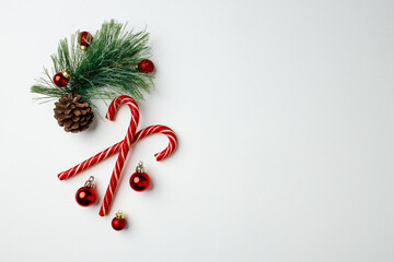 Candy canes and red Christmas baubles on white