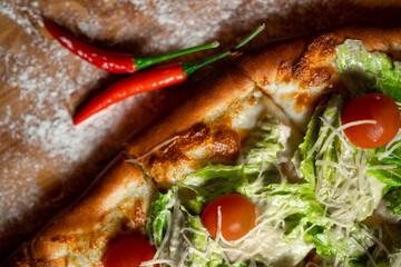 Homemade pinsa with tomatoes, mozzarella and pepperoni.