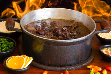 Feijoada. Traditional Brazilian food. Background with fire.