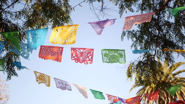 Colorful mexican perforated papel picado banner, festival colourful paper garland. Multi colored hispanic folk carved tissue flags, holiday or carnival. Authentic fiesta decoration in Latin America.