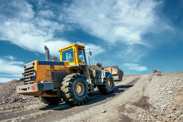 Front-end loader in the mode of transporting mountain soil. Earthworks in mountainous areas.