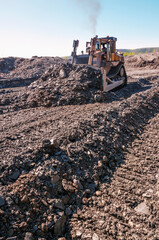 Mining of natural gold in a mountainous forest area. Bulldozers in the process of working in a mountain forest area on a summer sunny day