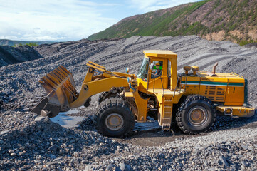 Front-end loader in the mode of transporting mountain soil. Earthworks in mountainous areas.