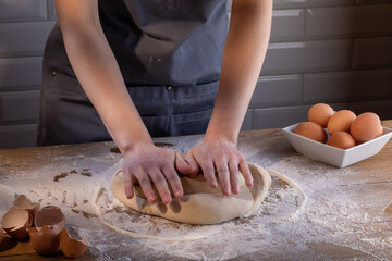 The chef's hands are kneading the dough for dumplings, pasta, bread, or pizza. Cooking dumplings – step by step guide.