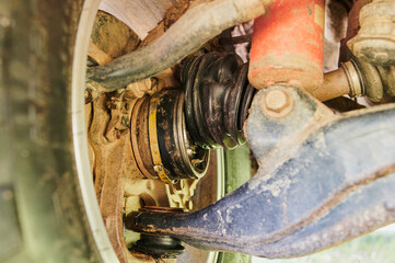 Old damaged CV joint duster close up fallen into the mud on the road.