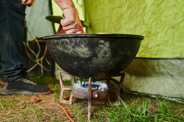 Hiking pot, Bowler in the bonfire. Fish soup boils in cauldron at the stake. Traveling, tourism,...