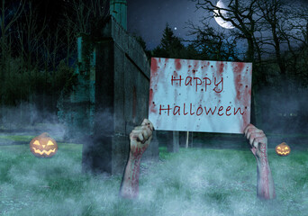 Hands sticking out of the ground in a cemetery with a Happy Halloween sign